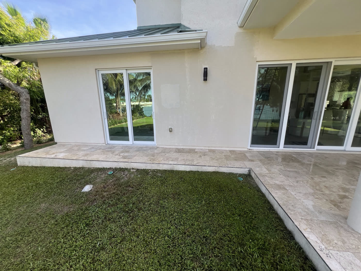 Waterfront patio & windows — Travertine · soft wash, by Cayman Clean & Blast, Grand Cayman